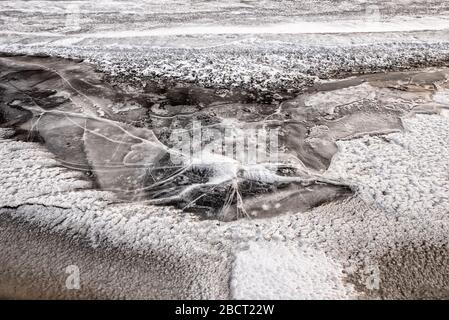 Regardez sur de la glace d'eau fissurée gelée avec dans le givre hiver Banque D'Images