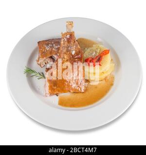 Jambe de chèvre rôtie avec tranches de pommes de terre cuites au four. Banque D'Images