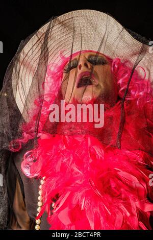 Une femme, vêtue de vêtements de deuil, portant une perruque rouge et pleurant, partant dans les rues pendant la procession funéraire Burial de la Sardine Banque D'Images