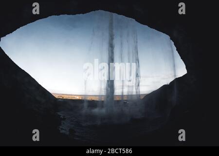 Seljalandsfoss vue de l'intérieur dans la lumière du soir avant le coucher du soleil, Islande. Banque D'Images