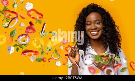 Dame afro-américaine avec bol de salade d'été fraîche et de légumes volants sur fond orange, collage Banque D'Images