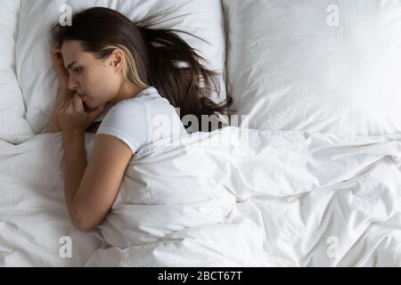 Jeune femme anxieuse se reposant dans le lit se sentant solitaire Banque D'Images