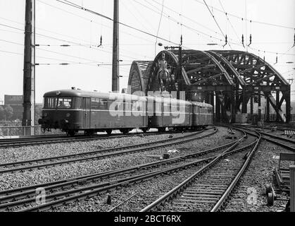 Train quittant la gare de Cologne en Allemagne 1975 avec des trains de locomotives électriques Banque D'Images