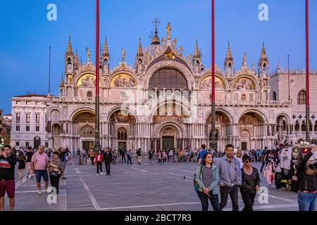 Les touristes se promenent en début de soirée autour de la place Saint Marc avec la basilique Saint Marc en arrière-plan, Venise, Italie Banque D'Images