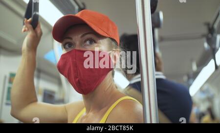 Une femme voyage une balade caucasienne à l'airtrain en train terrestre avec un masque médical de protection. Fille touristique à airtrain avec respirateur. Masque de personnes. Banque D'Images