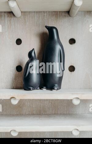 Une figurine noire à pingouins sur fond en bois. Décoration maison en céramique. Banque D'Images