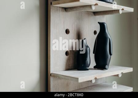 Une figurine noire à pingouins sur fond en bois. Décoration maison en céramique. Banque D'Images