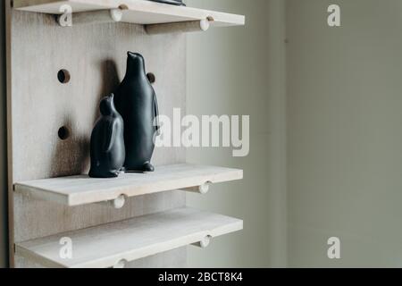 Une figurine noire à pingouins sur fond en bois. Décoration maison en céramique. Banque D'Images