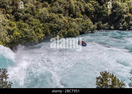 Jetboat se déplaçant dans l'eau turbulente sous les chutes Huka, Taupo, Nouvelle-Zélande Banque D'Images