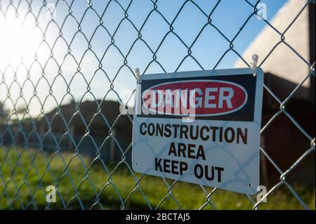 Signe de danger sur la clôture de la chaîne entourant le chantier Banque D'Images