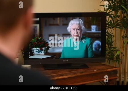 Les gens de Wandsworth, Londres, regardent la reine Elizabeth II livrer son allocution à la nation et au Commonwealth en relation avec l'épidémie de coronavirus. Banque D'Images