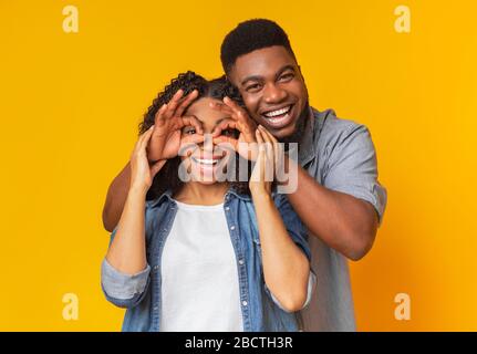 Joyeux ami Afro Boyfriend à faire des lunettes drôles à rire petite amie Banque D'Images