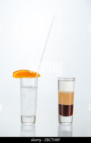 Gros plan sur un verre de cocktail b-52 sur fond blanc avec espace de copie.