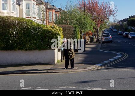 Londres, Royaume-Uni. Coronavirus. Un homme semble fumer ouvertement de crack cocaïne au coin des rues résidentielles, principalement désolées, pendant le covid- 19 Banque D'Images