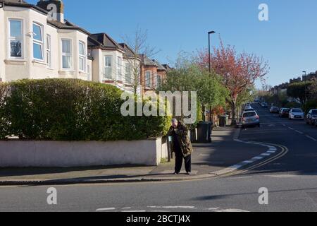 Londres, Royaume-Uni. Coronavirus. Un homme semble fumer ouvertement de crack cocaïne au coin des rues résidentielles, principalement désolées, pendant le covid- 19 Banque D'Images