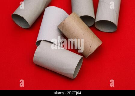 Tubes en carton à partir de papier hygiénique. Restes de papier toilette sur un fond rouge Banque D'Images