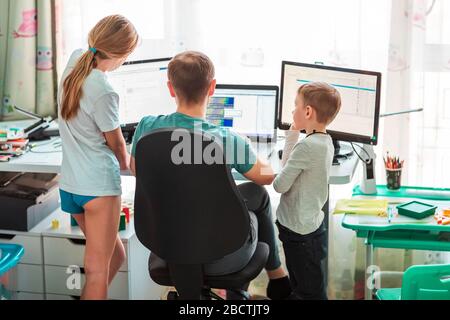 Père avec enfants essayant de travailler de la maison pendant la quarantaine. Restez à la maison, travaillez à partir du concept de maison pendant la pandémie de coronavirus Banque D'Images