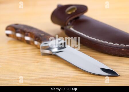 Magnifique couteau de chasse et gaine dans la table en bois Banque D'Images
