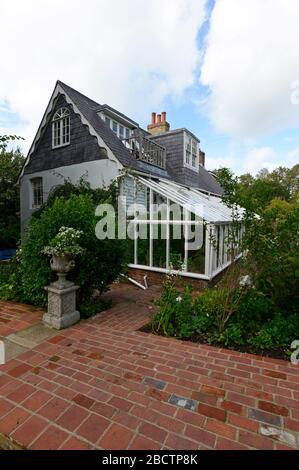 Vue sur la Maison de Monk, autrefois la maison de Virginia Woolf, Rodmell, East Sussex, Royaume-Uni, depuis le jardin, avec une véranda en bois et en verre. Banque D'Images