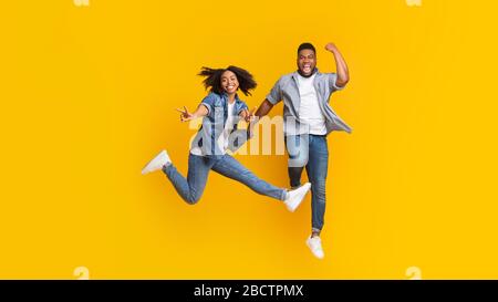 Un couple joyeux qui se trompe ensemble, qui se place dans l'air et montre le signe de la paix Banque D'Images