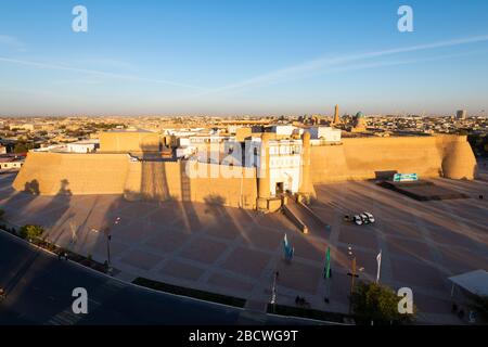 Forteresse de Boukhara (Ark), Ouzbékistan au coucher du soleil montrant le vieux mur de la ville, le complexe architectural po-i-Kalan (POI Kalon) et le minaret de Kalyan. Banque D'Images