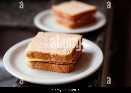 petit sandwich simple avec pain, jambon et mozzarella sur une plaque blanche Banque D'Images