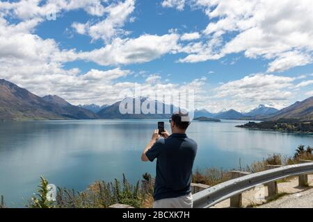 Un homme prenant une photo de la vue avec son smartphone Banque D'Images