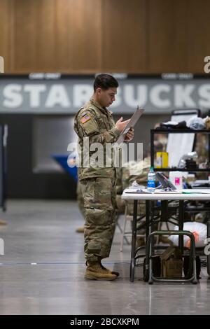 Un soldat travaille à la préparation de l'hôpital de campagne du Centre d'événements de terrain CenturyLink à Seattle le 5 avril 2020. L'hôpital chirurgical de l'armée mobile, actuellement pour les cas non-COVID-19, comprend du personnel médical militaire de plusieurs unités, y compris les soldats du 10ème hôpital de campagne du 627ème Hospital Center à fort Carson, Colorado, la 62ème Brigade médicale de la base conjointe Lewis-McChord, Washington et d'autres. Les responsables ont déclaré que l'hôpital est maintenant prêt à accepter les patients. Banque D'Images