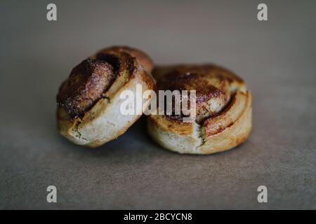 Photo de deux gâteaux roulés à la cannelle sur fond netural propre. Frais cuits. Banque D'Images