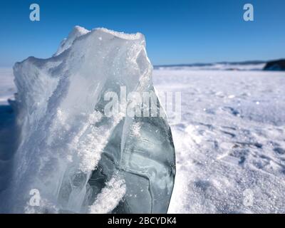 La beauté verglacière du cube de glace, formes inhabituelles. Gros cube de glace limpide recouvert de neige blanche. Lac Baikal, Russie Banque D'Images