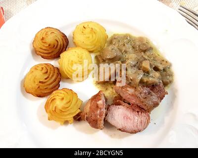 filet de porc dans la croûte de bacon avec champignons sautés et pommes de terre duchesse Banque D'Images