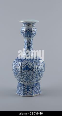 Vase. Recherche dans ProgressTall, vase à huit côtés, bosses à base droite sur corps bulbeux, long col fin, petite partie bulbeuse haut, bouche torreneuse; peint en bleu sous-brillant sur blanc avec motif floral global, fond de bordure en laine d'agneau, bord de feuille haut de corps bulbeux secte vase Banque D'Images