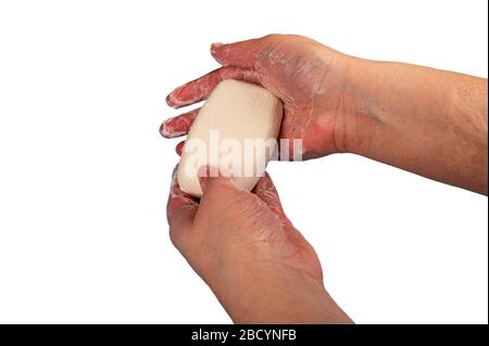 Quelqu'un prend ses mains avec un bout de savon de toilette. Le lavage fréquent des mains au savon est une prévention de l'infection par COVID-19. Gros plan. Isoler o Banque D'Images