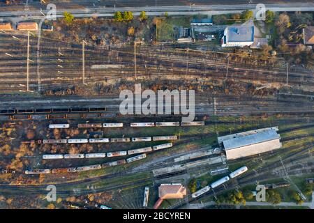 Vue aérienne de divers trains de transport ferroviaire avec marchandises sur la gare, vue de dessus. Banque D'Images