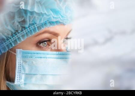 Infirmière chirurgicale ou médecin avec masque et capuchon. Soins de santé, chirurgie. Gros plan portrait de la jeune femme caucasienne modèle sur fond blanc Banque D'Images