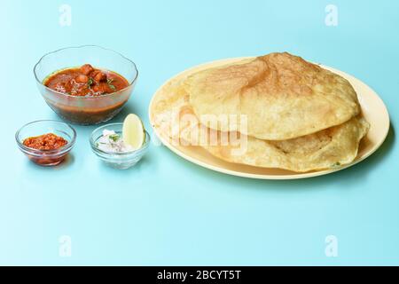 Plat indien épicé Chick Peas curry aussi connu sous le nom de Chole Bhatura et Chana Masala, déjeuner traditionnel du nord de l'inde servi avec des puri frits ou des pains plats Banque D'Images