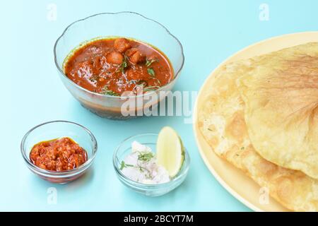 Plat indien épicé Chick Peas curry aussi connu sous le nom de Chole Bhatura et Chana Masala, déjeuner traditionnel du nord de l'inde servi avec des puri frits ou des pains plats Banque D'Images