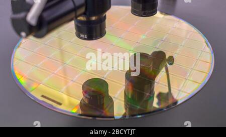 Gros plan de la galette de silicium avec des micropuces sur le procédé de la machine en examinant au microscope et en vérifiant la qualité . Mise au point sélective. Banque D'Images