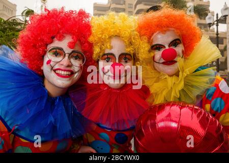 Un groupe de femmes, vêtues de clowns et souriantes, parleurs dans les rues pendant le Carnaval de Daytime Banque D'Images