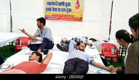 Décembre 2019, Hisar, Haryana, Inde : Camp de don de sang organisé par "l'ONG de l'inspire Inde" dans un village extérieur, heureux donneurs de sang sur les lits. Banque D'Images