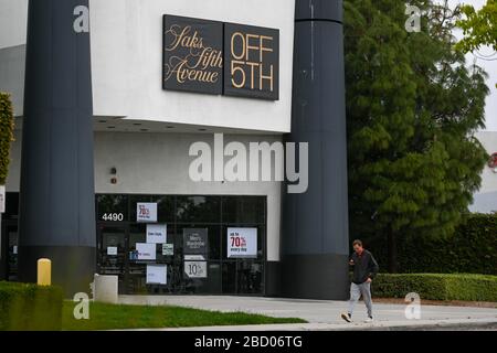 Un homme passe devant un magasin fermé de la cinquième avenue Saks à l'intérieur du centre commercial Ontario Mills, le samedi 4 avril 2020, en Ontario, en Californie, aux États-Unis. (Photo par IOS/Espa-Images) Banque D'Images