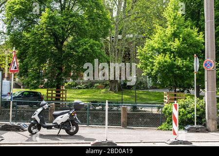 Scooter séjour dans la rue de la ville près d'un parc en été journée ensoleillée à Baden-Baden. Allemagne. Contexte du bâtiment. Banque D'Images