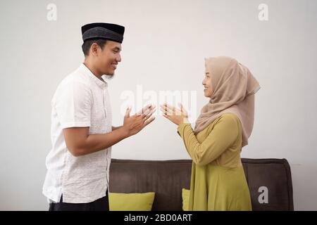 l'homme et la femme secouent la main musulmane touchant s'excusant sur eid moubarak Banque D'Images