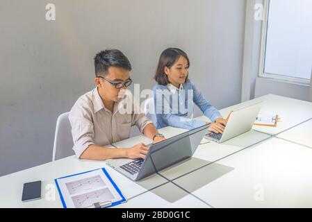 Jeunes professionnels travaillant sur ordinateur portable sur le lieu de travail des entreprises Banque D'Images