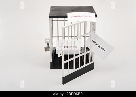 Concept de verrouillage partiel du coronavirus avec prison déverrouillée avec signes de coronavirus à l'intérieur et à l'extérieur de la prison et un signe de verrouillage se sortant des barreaux de prison Banque D'Images