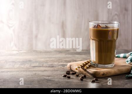 Café glacé ou Latte à la caffe dans un grand verre sur une table en bois. Espace de copie Banque D'Images