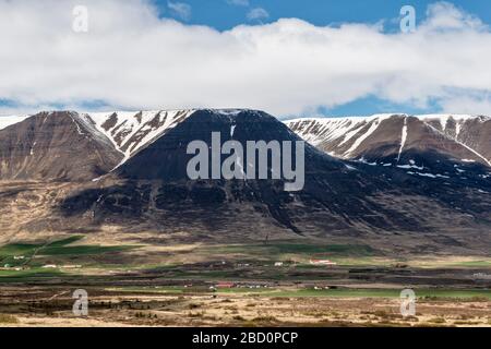 Petites fermes dans une vallée au pied des montagnes dans le nord de l'Islande sur la route vers Akureyri. Une scène de paysage typique Banque D'Images