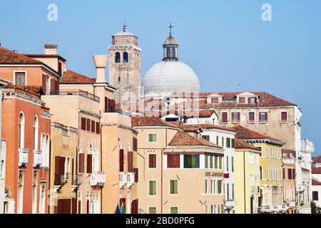 Venise, Italie-février 2020; gros plan d'un grand nombre de maisons traditionnelles colorées avec des toits de tuiles rouges et un campanile et un dôme d'église Banque D'Images