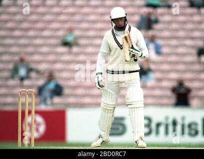 The Oval, Londres, 19 mai 1990. Surrey/Hampshire. Surrey openin batsman, la chauve-souris de Grahame Clinton se casse d'une livraison par Kevin Shine de Hampshire comme le regarde David Gower. Banque D'Images