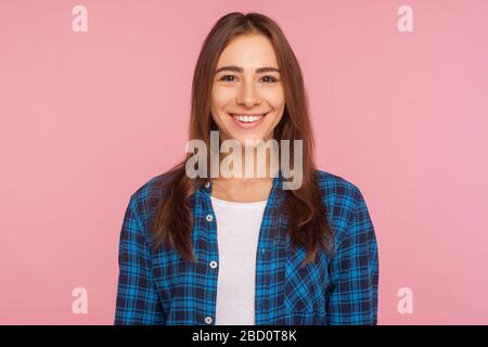 Portrait d'une sympathique fille bien dénaturée dans un maillot à carreaux souriant sincèrement à l'appareil photo, regardant satisfait content de la vie, se réjouissant des nouvelles positives. Banque D'Images